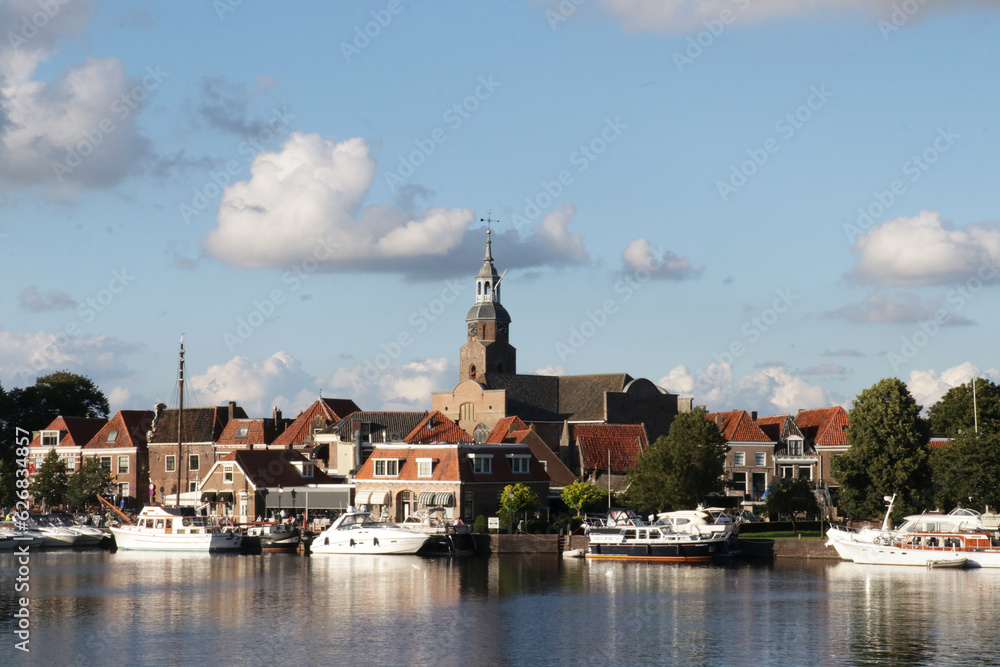 View of the harbor with boats in the small Dutch town called Blokzijl. Captured in summer during a sunny blue sky day.
