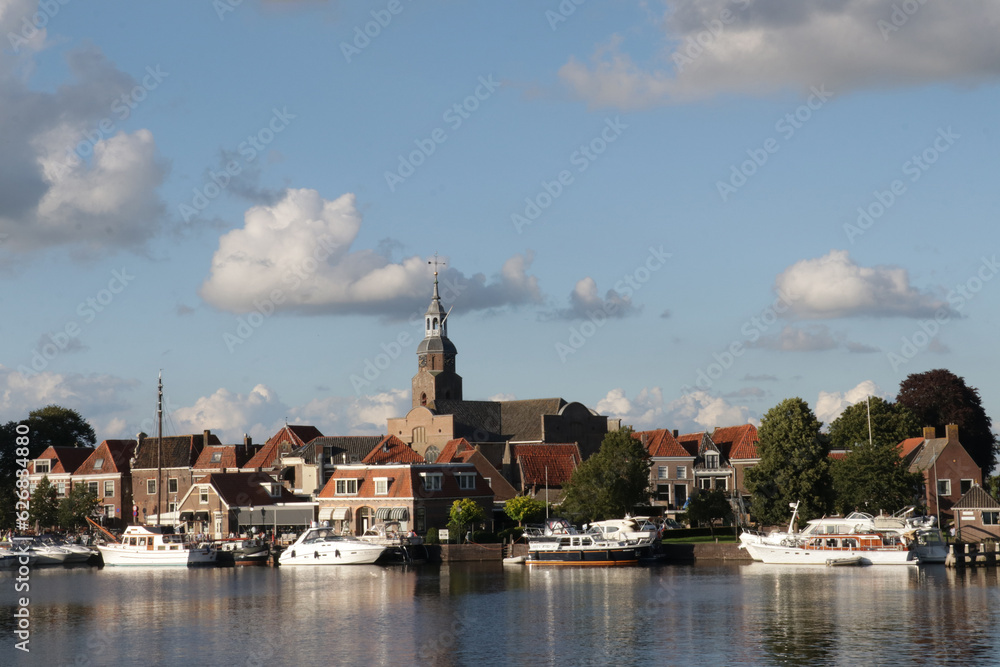 Fototapeta premium View of the harbor with boats in the small Dutch town called Blokzijl. Captured in summer during a sunny blue sky day.