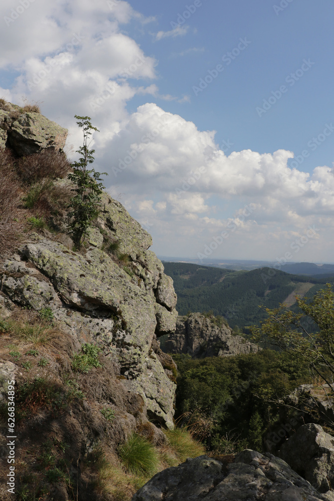 Vertical view from the Bruchhauser Steine near Olsberg, Sauerland, Germany. The big stone is part of a series of rocks on a mountain in a rolling hills landscape.