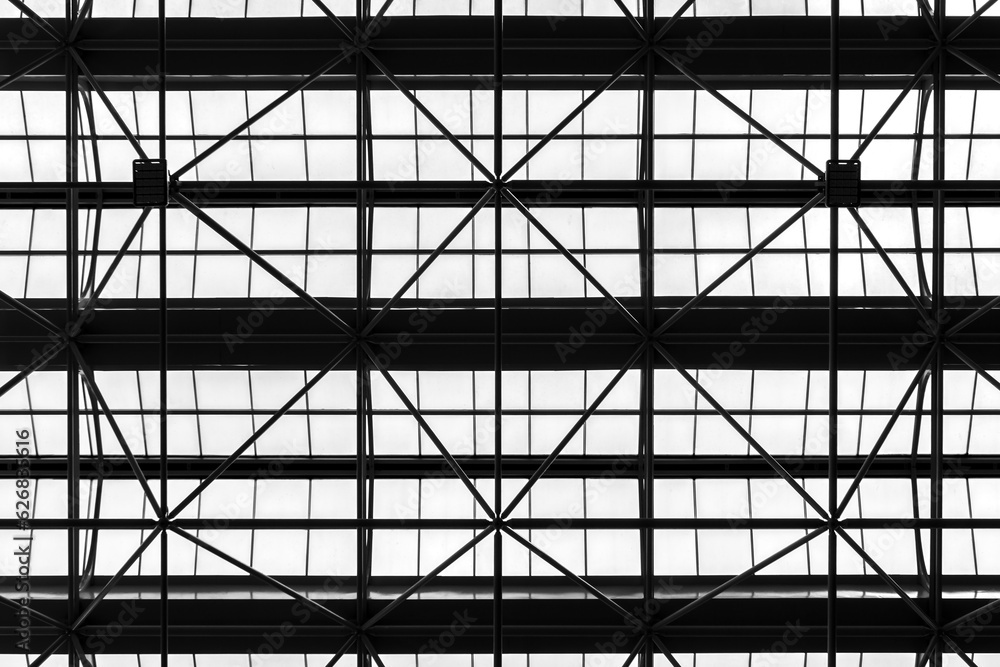Black pattern from low angle view of silhouette roof truss constructure and white transparent tiled or milk glass in green house construction. Background for environment or energy saving concept. Black pattern from low angle view of silhouette roof truss constructure and white transparent tiled or milk glass in green house construction. Background for environment or energy saving concept.
