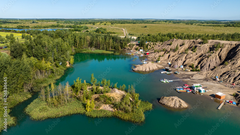 panoramic view of the high hills of the lake with turquoise water and green forest from the reserve in the Tula region taken from a drone