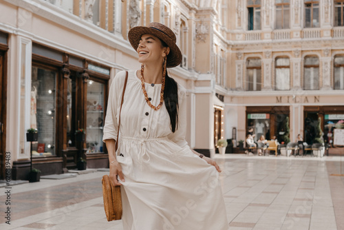 attractive woman walking in shopping street in Italy on vacation dressed in white summer fashion dress