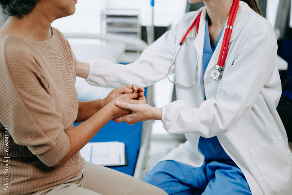 Doctor and senior female patient who lie on the bed while checking pulse, consult and explain with nurse taking note in hospital wards or clinic.. Doctor and senior female patient who lie on the bed while checking pulse, consult and explain with nurse taking note in hospital wards or clinic..
