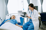 Woman Doctor and patient discussing something while sitting on examination bed in modern clinic or hospital . Medicine and health care concept.