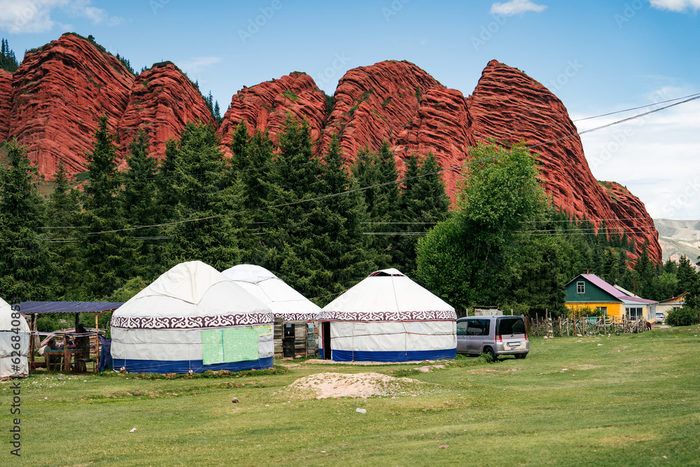 White yurts stand at the foot of the mountain. Mountain gorge Jety Oguz. Kyrgyzstan's picturesque destination. Travel photo 
