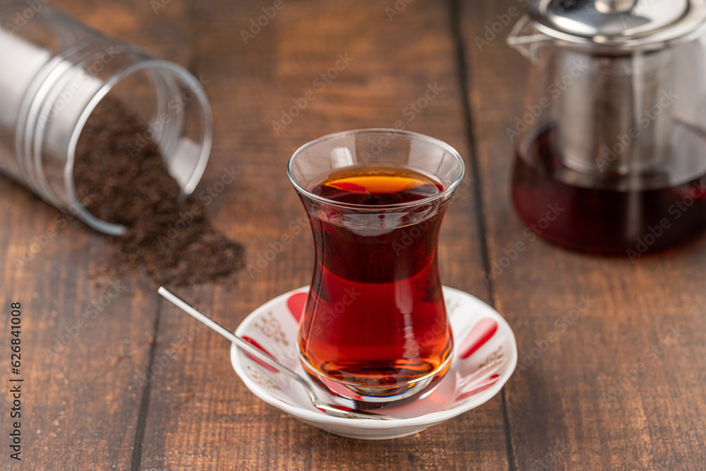 Freshly brewed turkish tea in thin-waisted glass cup on wooden table Freshly brewed turkish tea in thin-waisted glass cup on wooden table