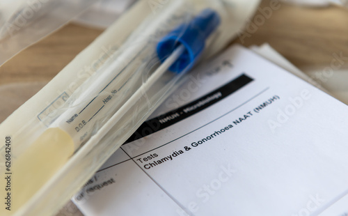 Photos A sample container and medical form for a Chlamydia and Gonorrhoea test