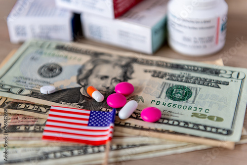 Foto A medical cost, big pharma concept with a glass of water, various medicine, US dollar bills and the American flag