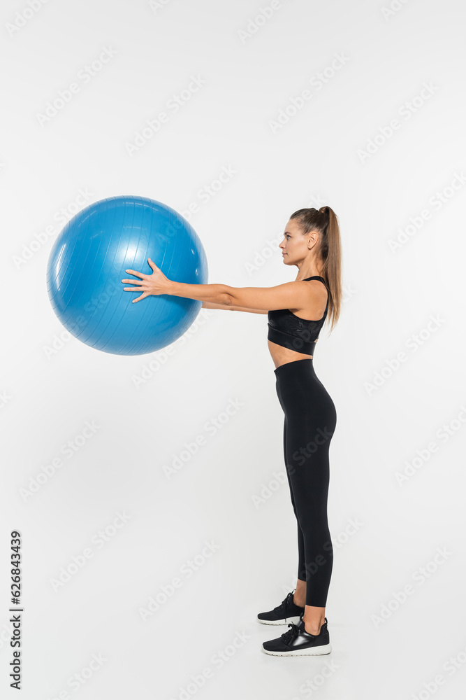fit sportswoman holding fitness ball while exercising on white background, athletic woman concept fit sportswoman holding fitness ball while exercising on white background, athletic woman concept