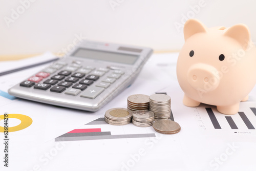 A pile of coins beside piggy bank and calculator with the concept of financial planning. saving money and financial concept. ideas for growth, economy, business and investing. Banking investment.