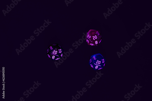 blue and pink colour dices for fantasy dnd and rpg tabletop games. Board game polyhedral dices with different sides isolated on black background