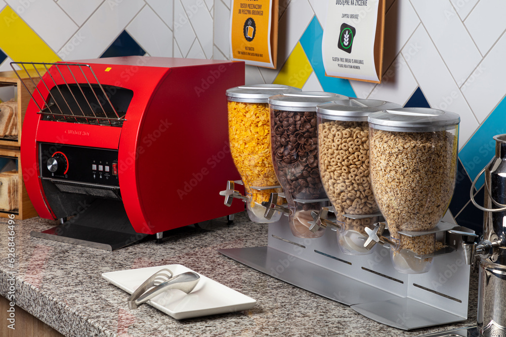 Foto de hotel breakfast buffet. a counter top with a toaster and cereal