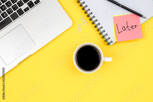 Laptop, notepad and coffee cup on yellow background, top view.