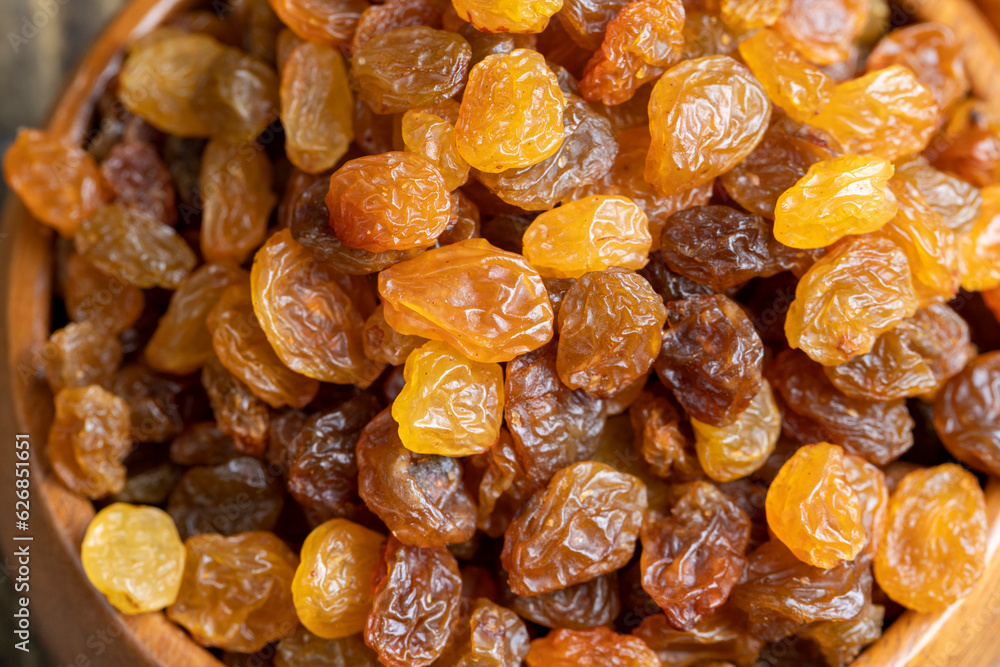 Dried yellow golden raisins on a board