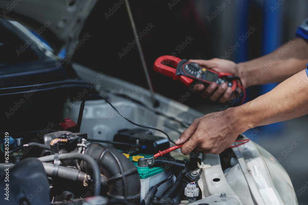 Professional mechanic checking and repairing a car. Auto mechanic working in garage. Repair service. Professional mechanic checking and repairing a car. Auto mechanic working in garage. Repair service.
