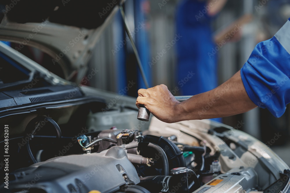 Professional mechanic checking and repairing a car. Auto mechanic working in garage. Repair service. Professional mechanic checking and repairing a car. Auto mechanic working in garage. Repair service.