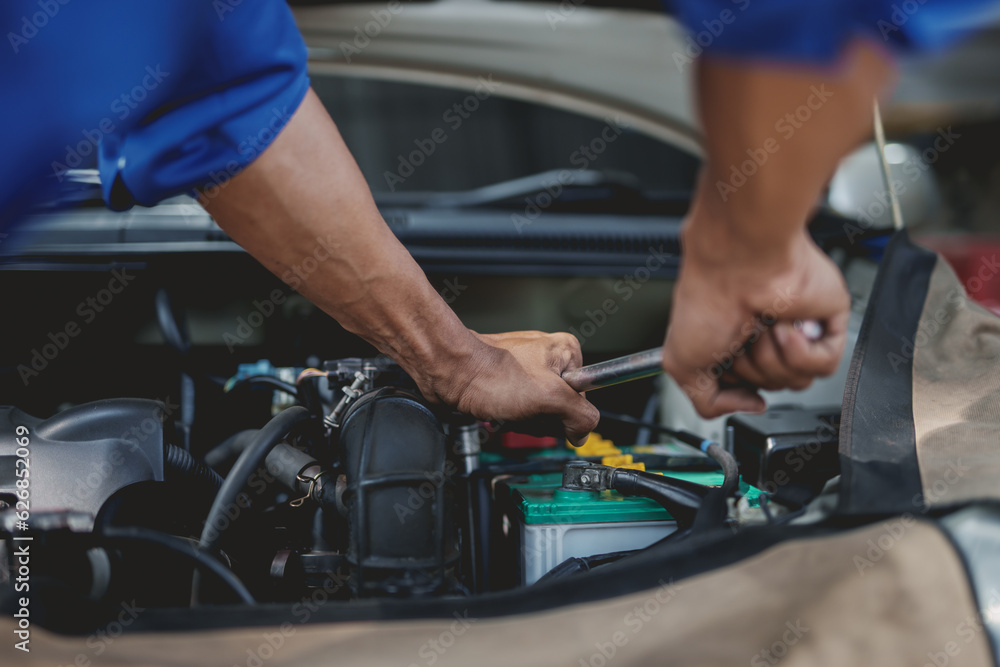 Professional mechanic checking and repairing a car. Auto mechanic working in garage. Repair service. Professional mechanic checking and repairing a car. Auto mechanic working in garage. Repair service.