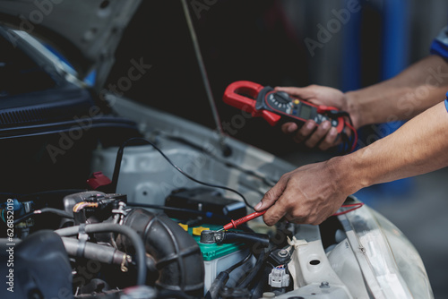 Professional mechanic checking and repairing a car. Auto mechanic working in garage. Repair service.