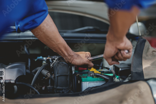 Professional mechanic checking and repairing a car. Auto mechanic working in garage. Repair service.