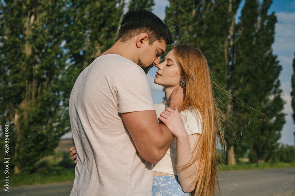 Cheerful woman with closed eyes standing with her boyfriend spending time together with landscape at background. Love story and countryside adventure Cheerful woman with closed eyes standing with her boyfriend spending time together with landscape at background. Love story and countryside adventure