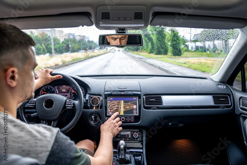 Man touching screen of a GPS navigation system in his car. © puhimec