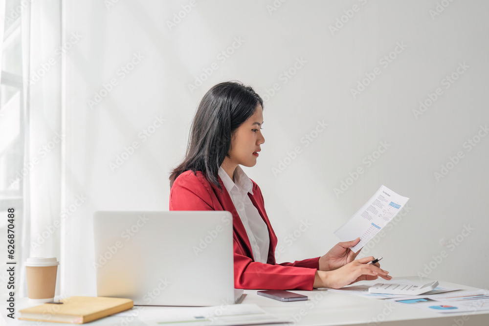 Businesswoman using a calculator to check company finances and earnings and budget. Business woman calculating monthly expenses, managing budget, papers, loan documents, invoices Businesswoman using a calculator to check company finances and earnings and budget. Business woman calculating monthly expenses, managing budget, papers, loan documents, invoices