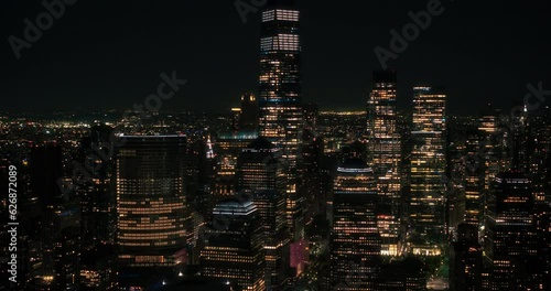 Aerial Helicopter Cinematic Night Scene with a Panoramic View with One World Trade Center Skyscraper and Vibrant Cityscape. Beautiful Office Buildings with Indoors Lights