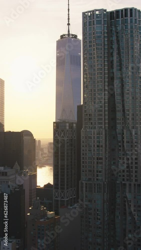 Vertical Screen: Aerial Helicopter Cinematic Scene Over a Brooklyn Bridge with Manhattan Cityscape. Beautiful Evening Sun Shining with Warm Sunset Light. Footage Focusing on One World Trade Center photo