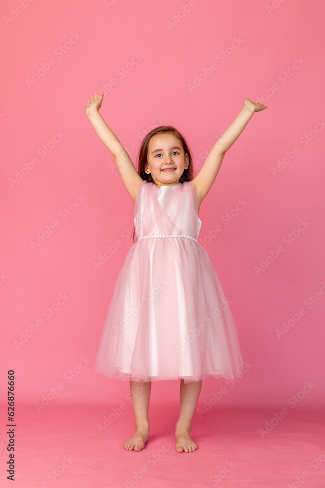 People, joy, fun and happiness concept. Relaxed happy birthday little girl with arms raised high celebrating cheerful, smiling happily, posing for picture People, joy, fun and happiness concept. Relaxed happy birthday little girl with arms raised high celebrating cheerful, smiling happily, posing for picture