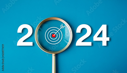 Happy new year 2024 with business concept banner. The big white 2024 year number with Target icon inside the golden magnifying glass on light blue background. Planning for goal and success concepts.