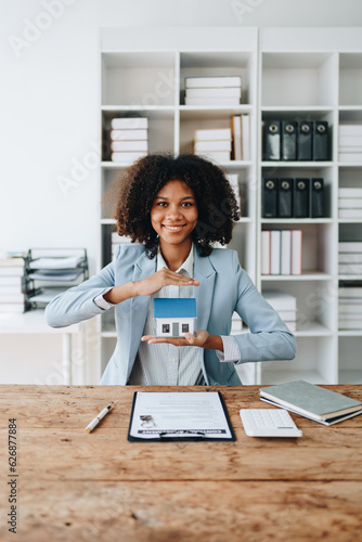 Fotografie Real estate african american, Agent, buy and sell land, property tax, show the concept of protecting the house to insure the risk of damage to the home