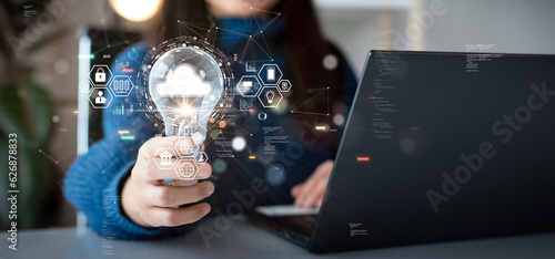 Woman holding light bulb with cloud icon. Digital technology concept, data sheet management with large database capacity and high security. Storage transition from computer to cloud computing.