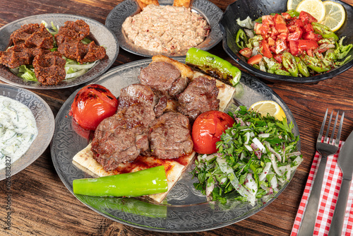 Turkish cuisine Meat Shish. Shish kebab prepared on a barbecue grill on hot coals with grilled vegetables. Grilled beef pieces on metal skewers.