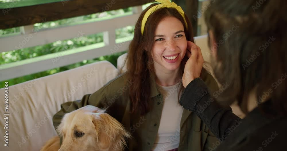 The brunette guy strokes the brunette girl on the cheek. A girl with a yellow bandage in a green sweater, a dog sits near the girl The brunette guy strokes the brunette girl on the cheek. A girl with a yellow bandage in a green sweater, a dog sits near the girl