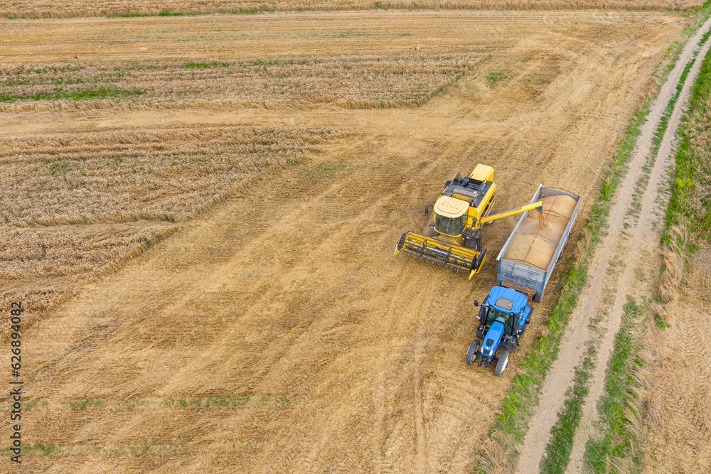 Obraz premium Combine harvester and a tractor working