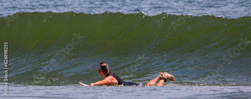 Surfer laying on surfboard ready to catch a wave photo