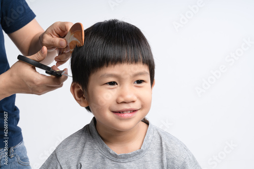 Asian boy got hair cut at home by his mother with paper scissors