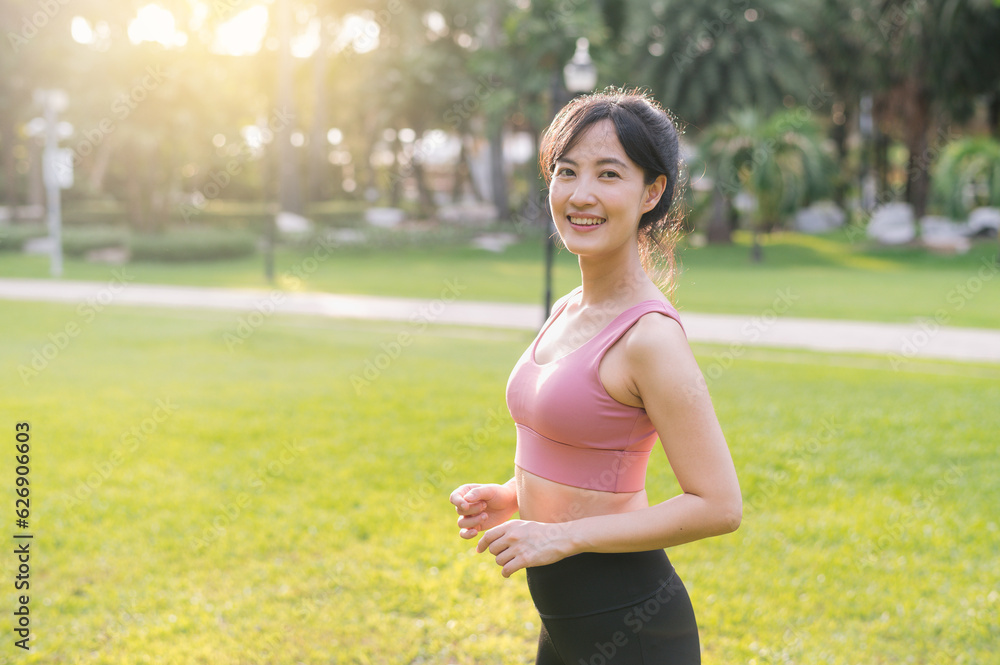 Experience wellness living as a happy, beautiful 30s Asian woman smiles and looks at the camera in a park at sunset. Embrace the concept of well-being Experience wellness living as a happy, beautiful 30s Asian woman smiles and looks at the camera in a park at sunset. Embrace the concept of well-being