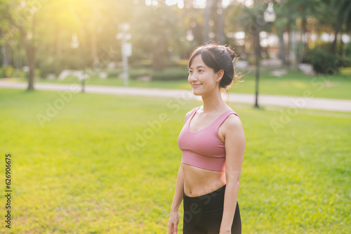 Experience the joy of a happy, fit female jogger in her 30s. Asian woman wearing pink sportswear, enjoying fresh air in a public park. Embrace wellness living and connect with nature.