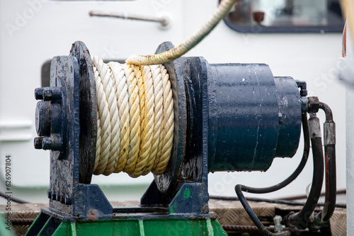 A winch drum with a wound rope mounted on a fishing boat. photo