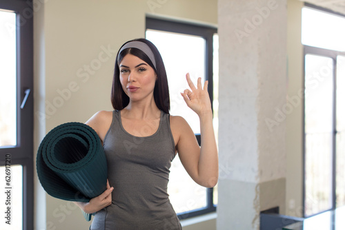 pretty young woman feeling happy, showing approval with okay gesture. yoga concept © kues1