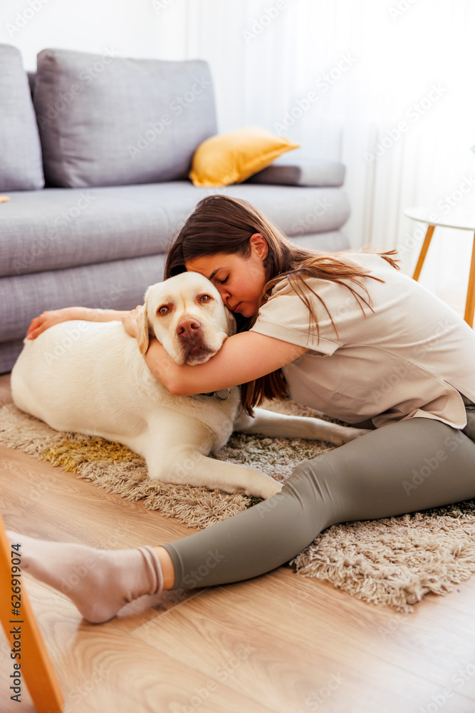 Woman stretching while working out at home with her per dog Woman stretching while working out at home with her per dog