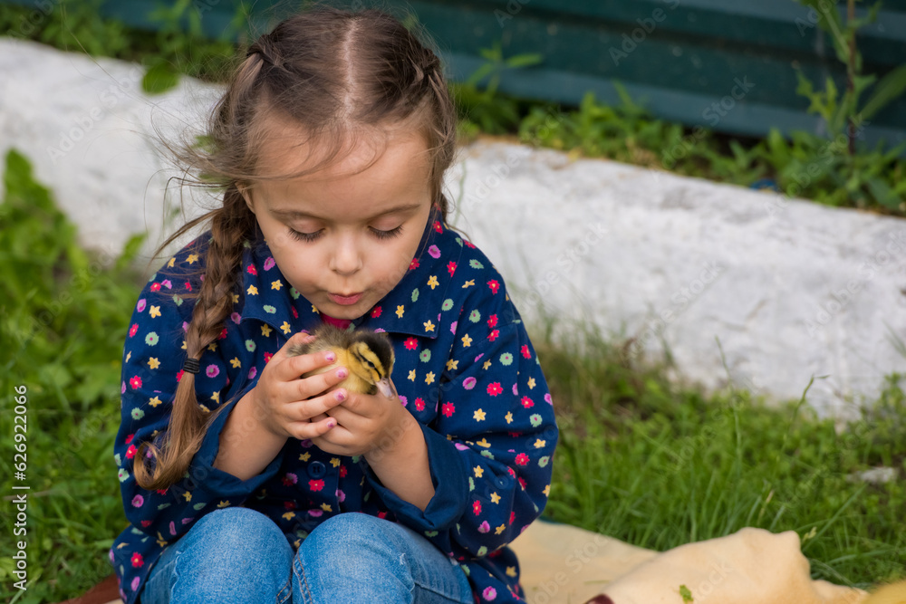 Cute happy little girl with of small ducklings in the garden. Nature background. Cute happy little girl with of small ducklings in the garden. Nature background.