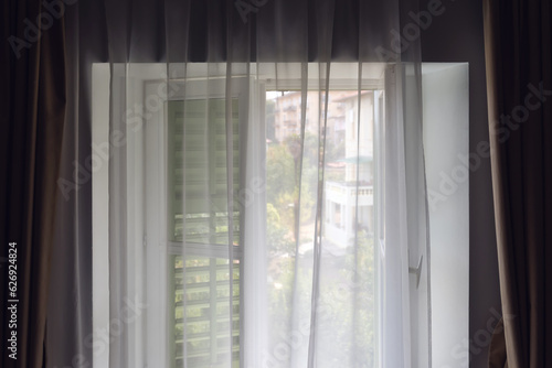 Window shutters and curtains at seaside apartment