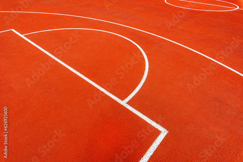 Minimalist abstract background of an orange tartan outdoor basketball court with white lines. © Bits and Splits
