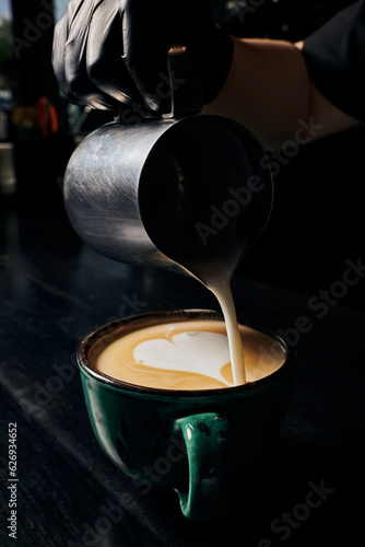 latte art, barista preparing cappuccino, pitcher with milk, cup with espresso, arabica, coffee