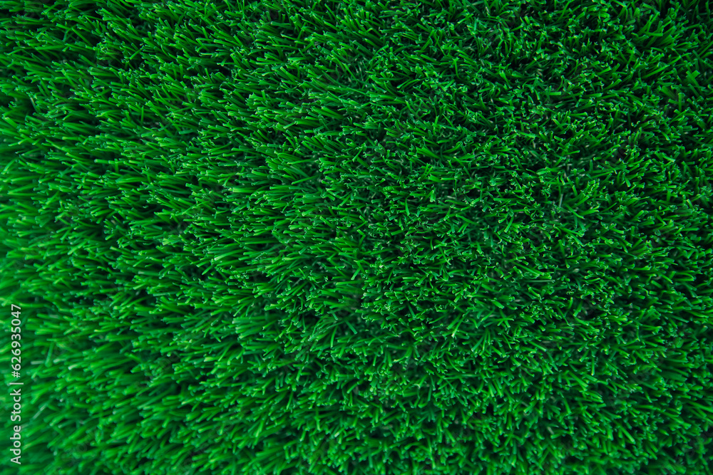 The texture of green artificial grass.Covering for sports stadiums and decorations. The texture of green artificial grass.Covering for sports stadiums and decorations.