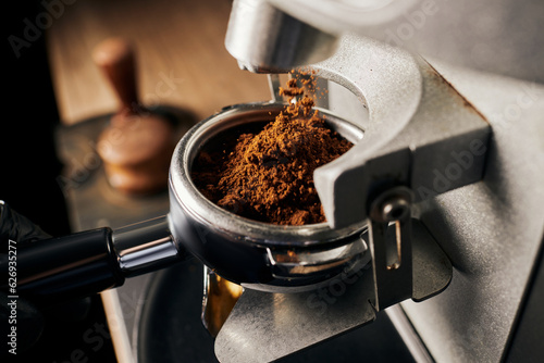 Foto preparation of espresso, close up of grinded coffee in portafilter, coffee machi