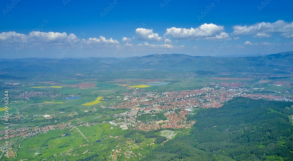 Panoramic shot on the city in the mountains in early spring. Top view from a drone