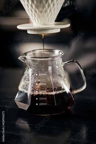 freshly brewed espresso dripping into glass pot from ceramic dripper, V-60 style alternative brew
